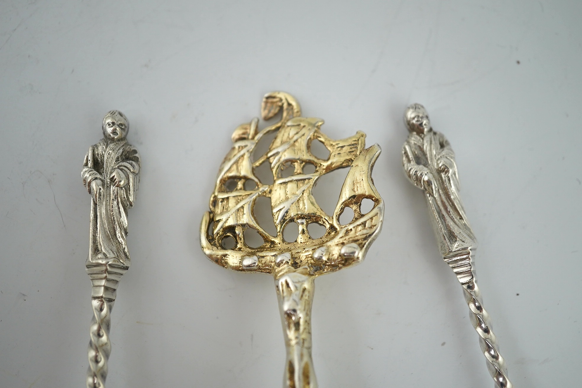 An early 17th century Dutch silver gilt spoon with galleon ship terminal, 18cm and two Victorian silver apostle spoons, Sheffield 1900, 17.5cm, 142g gross. Condition - fair